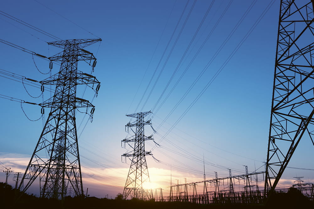 Electricity pylons in front of a sun set.
